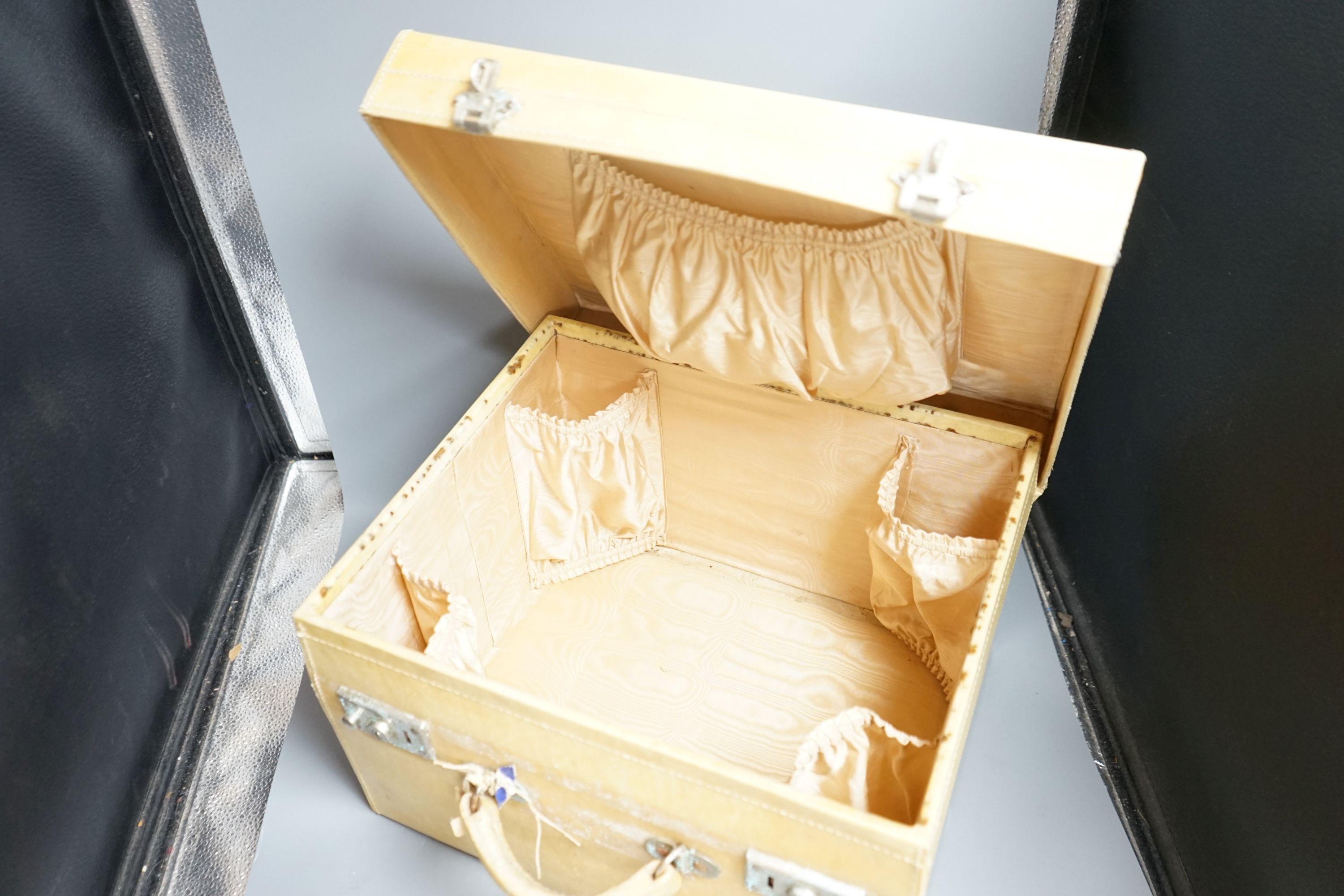 A top hat (boxed) and a cream vanity case